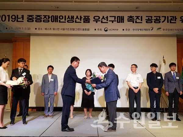 5일 서울가든호텔에서 개최된 '2019년 중증장애인생산품 우선구매 촉진 공공기관 워크숍'에서 이영만(오른쪽) 수원교육지원청 경영관리국장이 보건복지부 장관 표창을 받고 있다.(사진=수원교육지원청)