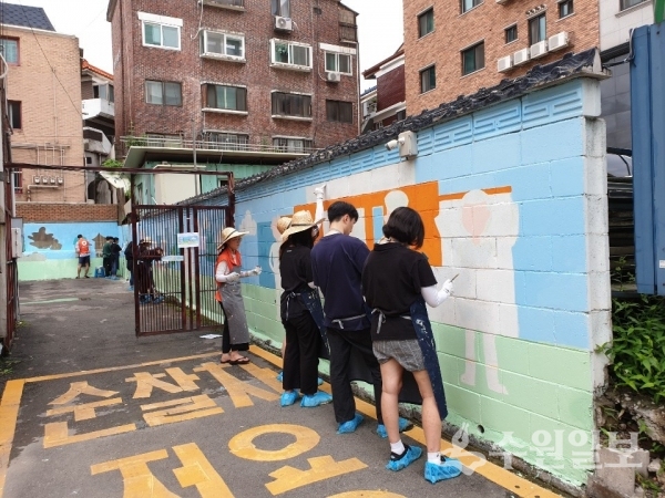 자원봉사자들이 팔달구 지동 골목길에서 벽화를 그리고 있다.(사진=팔달구)
