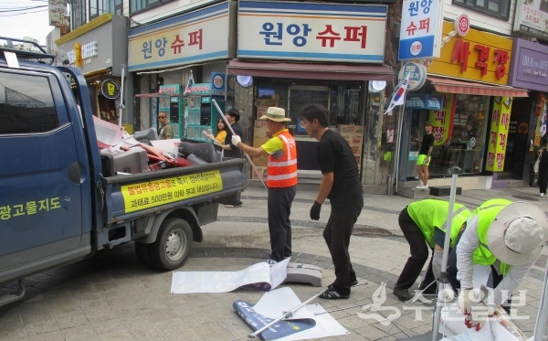 압수되는 수원역 테마거리의 불법 유동광고물.(사진=팔달구)