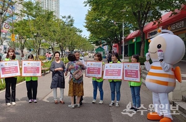 영통수다하모니 단원들이 2일 영통역에서 치매어르신 등과 포옹을 하고 있다. (사진=수원시)