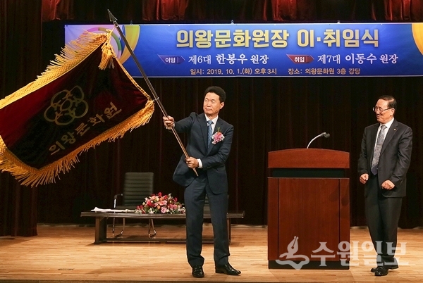 이동수 신임 의왕문화원장(왼쪽)이 깃발을 흔들고 있다. 오른쪽은 전임인 한봉우 원장.(사진=의왕시)