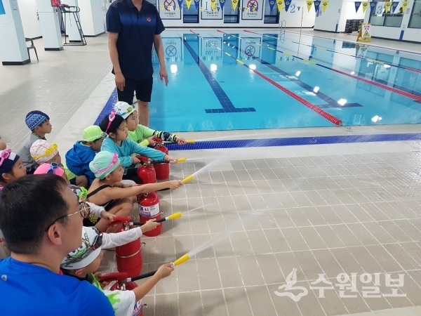 어린이들이 수영장에서 소화기를 다루고 있다.(사진=의왕시)