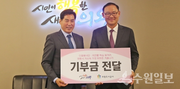 최욱 의왕도시공사 사장(오른쪽)이 김상돈 의왕시장에게 기부금을 전했다.(사진=의왕시)