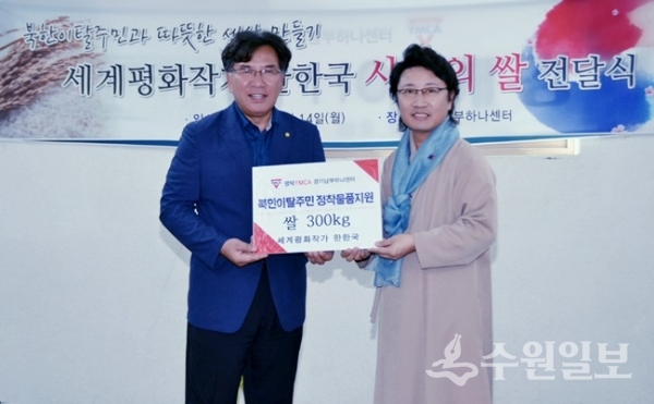 한한국(오른쪽) 세계평화작가가 경기남부하나센터 소태영 소장에게 평화재능나눔 쌀 전달식을 하고 있다.(사진=경기도)