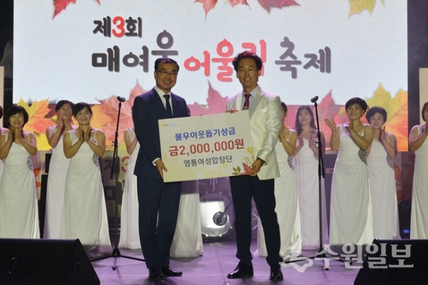 정창준(오른쪽) 영통여성합창단장이 송영완 영통구청장에게 불우이웃돕기 성금을 전달하고 있다.(사진=영통구)