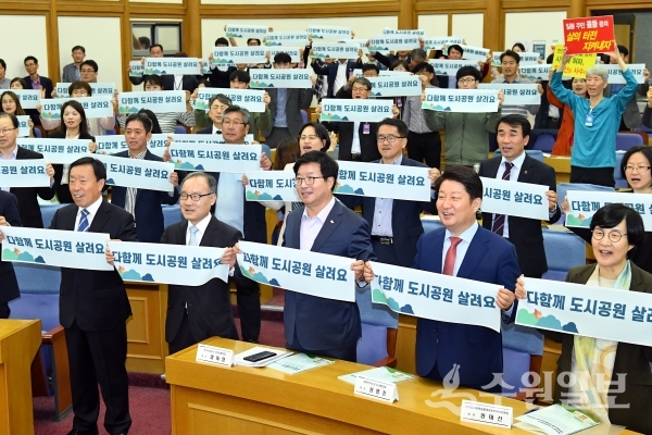 염태영 전국시장·군수·구청장협의회장이 22일 오후 국회에서 열린 도시공원일몰제 토론회에서 '다함께 도시공원 살려요'라는 팻말을 들었다.(사진=전국시장군수구청장협의회)