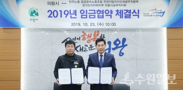 김상돈 의왕시장과 손재선 의왕시 공무직지회장이 협약서를 들고 포즈를 취했다.(사진=의왕시)