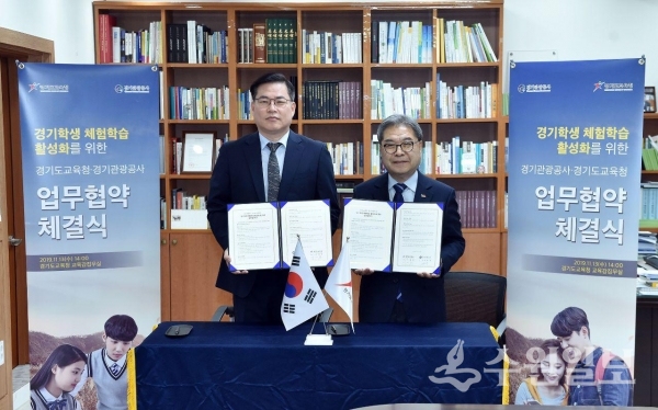 이재정 경기도교육감(오른쪽)과 유동규 경기관광공사 사장이 업무협약서를 들어 올린 뒤 포즈를 취했다.(사진=경기도교육청)