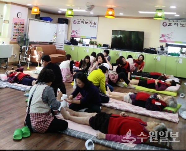 매탄3동 발사랑 이웃사랑 봉사단이 파장동 효자노치원을 찾아 어르신들을 대상으로 발마사지 봉사활동을 펴고 있다.(사진=매탄3동)
