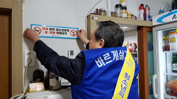 바르게살기위원회 회원이 파장동의 업소를 방문해 스티커를 붙이고 있다.(사진=파장동)