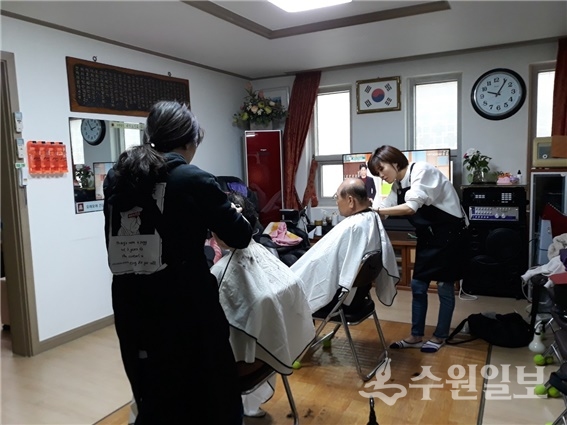 권선구 머털봉사단이 어르신들의 머리를 매만지고 있다.(사진=권선1동)