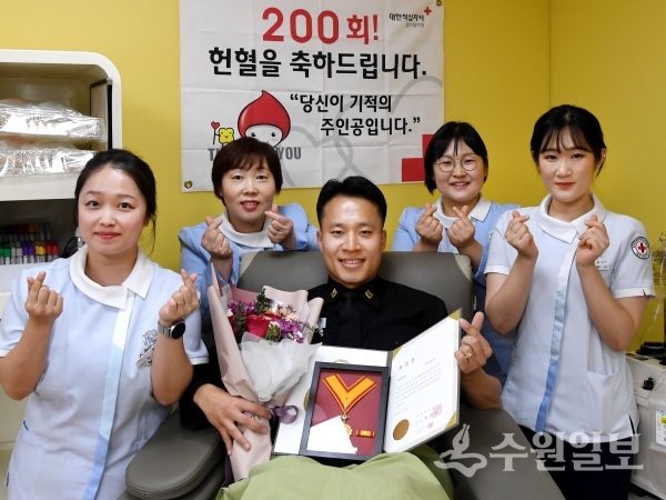 20년 간 꾸준한 헌혈로 헌혈 유공장 명예대장을 받은 최호진 중사(가운데).(사진=해군 제2함대사령부)