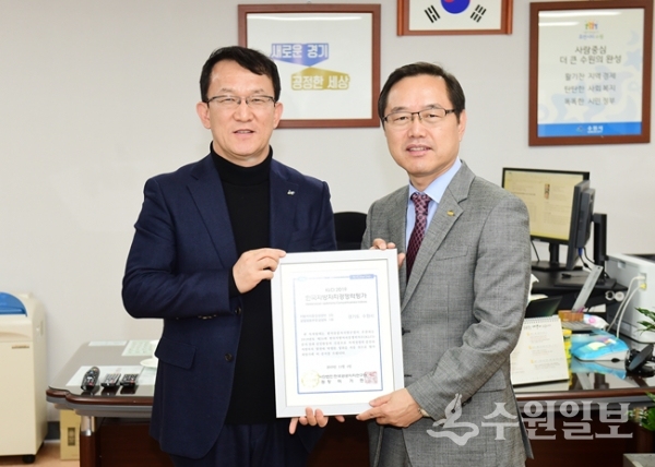 이기헌 한국공공자치연구원장(오른쪽)이 조청식 수원시 제1부시장에게 인증패를 전달한 후 기념촬영을 하고 있다.(사진=수원시)