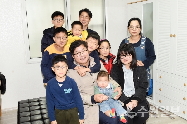 김용주 씨 가족이 지난해 12월 수원휴먼주택으로 이사 온 날 염태영 수원시장(앞줄 가운데)과 함께 기념사진을 찍고 있다.(사진=수원시)