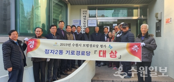 권찬호 수원시 복지여성국장(오른쪽 7번째)과 신갑신 기로경로당 회장(오른쪽 8번째)을 비롯한 관계자들이 현판 전달식 후 기념촬영을 하고 있다.(사진=수원시)