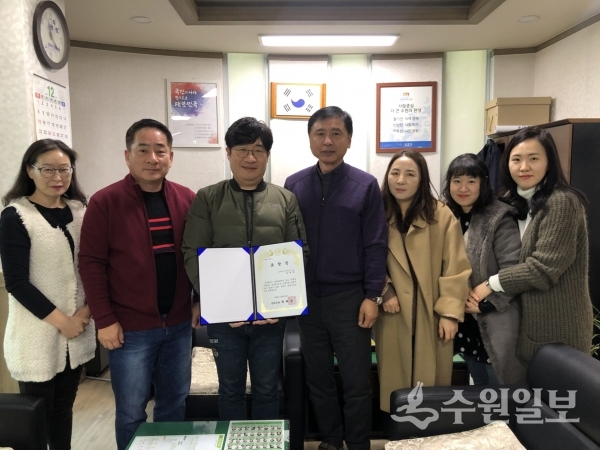 김우영 호매실동장(오른쪽 네번째)와 임재영 워시앤조이 호매실점 대표가 백혜련 국회의원상을 들고 기념사진을 찍고 있다.(사진=호매실동)