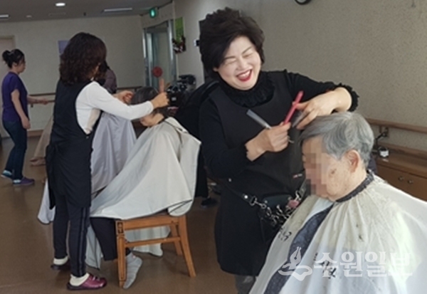 장안구에서 실시한 미용봉사에서 봉사자가 어르신의 머리를 매만지고 있다.(사진=장안구)