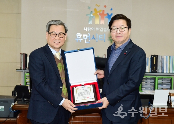 염태영 수원시장(오른쪽)이 김병오 한국환경전문기자협회장으로부터 상패를 전달받고 있다. (사진=수원시)