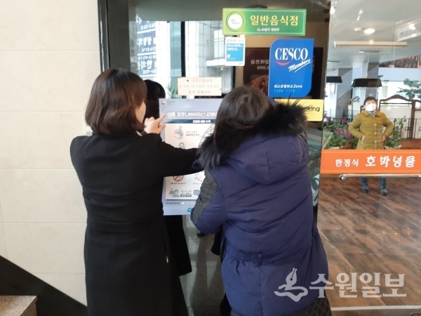 영통구청 직원들이 신종 코로나바이러스 예방 안내문을 붙이고 있다.(사진=영통구)