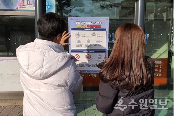 장안구 관계자들이 신종 코로나바이러스 예방 수칙 안내문을 붙이고 있다.(사진=장안구)