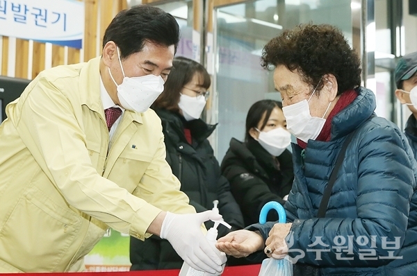 김상돈 의왕시장(왼쪽)이 어르신의 손소독을 도와주고 있다.(사진=의왕시)