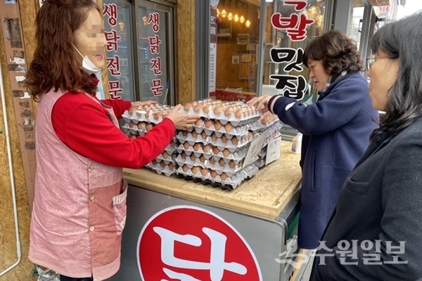 장안구청 직원들이 시장에서 물건을 사고 있다.(사진=장안구)