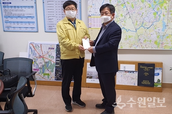 이정섭 팔달구 마을만들기협의회장(오른쪽)이 김용덕 수원시 안전교통국장에게 성금을 전달하고 있다.(사진=수원시)