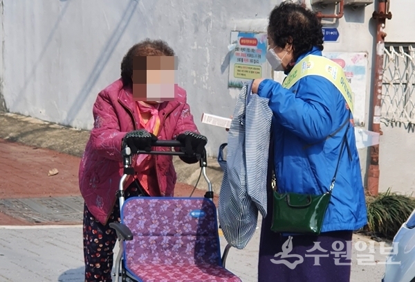 행궁동 지역사회보장협의체(오른쪽) 위원이 주민에게 위기가구 발굴 홍보를 하고 있다.(사진=행궁동)