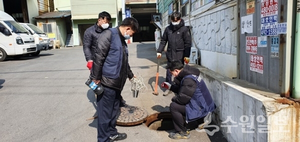 경기도 광역환경관리사업소 점검반이 우수관로를 이용한 불법폐수 유출여부를 점검하기 위해 도로 맨홀 뚜껑을 열고 있다.(사진=경기도)