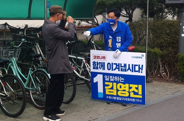 더불어민주당 김영진 후보가 선거 유세 중 주민과 주먹 인사를 나누고 있다.(사진=수원일보)