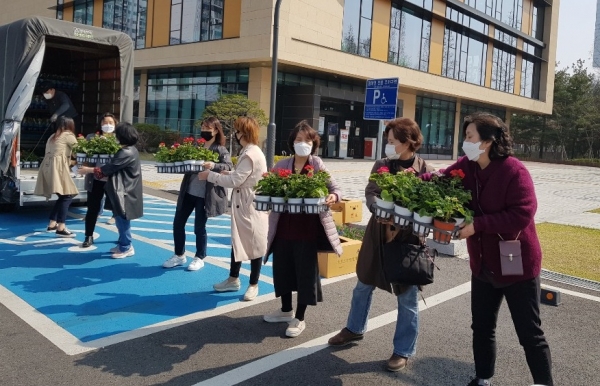 영통구 화훼농가 돕기 캠페인에 참가한 어린이집 원장들이 6일 꽃을 나르고 있다.(사진=영통구)