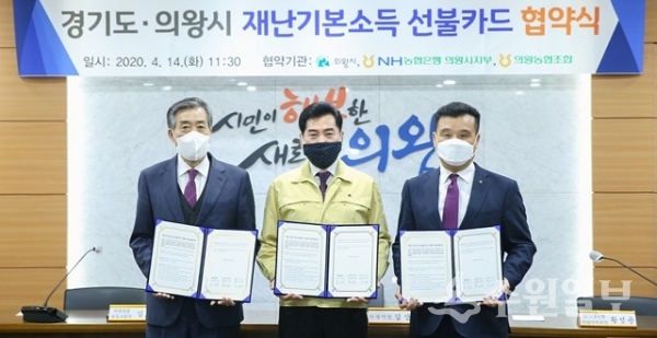 김상돈 의왕시장(가운데)과 황성용 NH농협은행 의왕시지부장(오른쪽), 김호영 의왕농협 조합장(왼쪽)이 14일 재난기본소득 배부 업무협약을 체결하고 협약서를 들어 보이고 있다.(사진=의왕시)