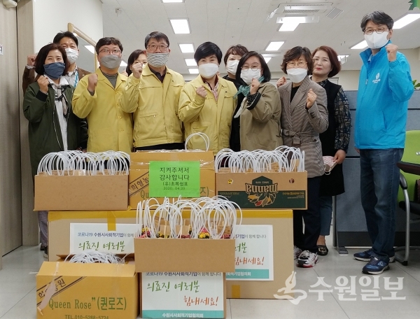 최옥순 수원시사회적기업협의회 상임대표(앞줄 왼쪽 5번째)가 최혜옥 장안구보건소장(앞줄 왼쪽 4번째)에게 격려품을 전달한 후 관계자들과 기념촬영을 하고 있다.(사진=수원시)