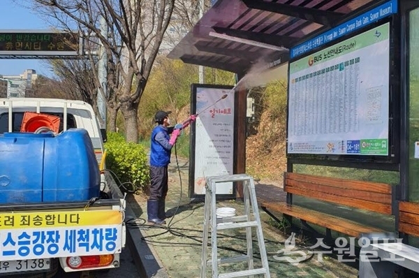 영통구 관계자가 버스정류장을 고압 세척하고 있다.(사진=영통구)