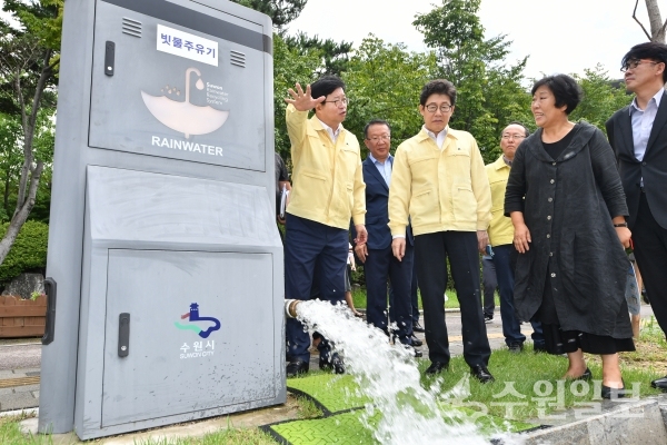 염태영 수원시장(왼쪽 끝)이 조명래 환경부장관(왼쪽 두번째)에게 레인시티 사업 중 하나로 활용되는 빗물주유기를 설명하고 있다.(사진=수원시)