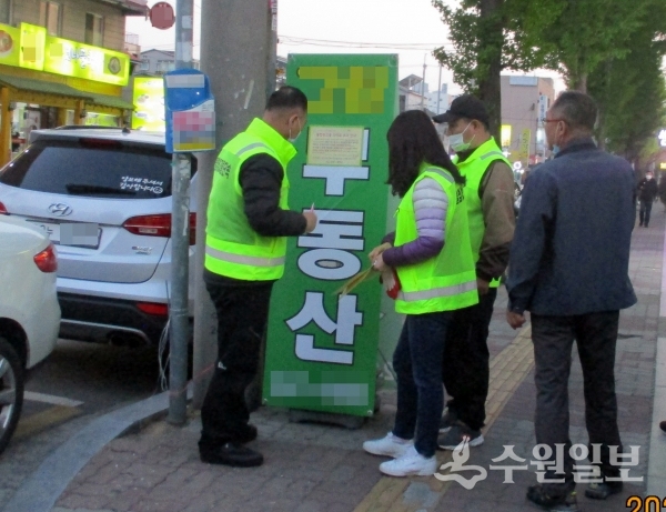 장안구 관계자들이 불법광고물을 확인하고 있다.(사진=장안구)