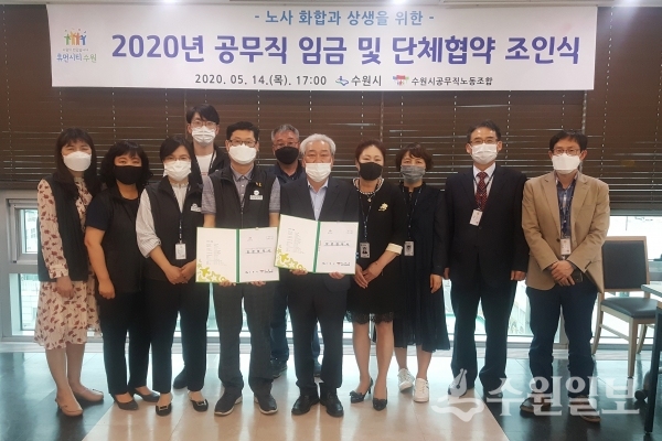 조진행 수원시 행정지원과장(앞줄 왼쪽 5번째), 김규동 수원시공무직노동조합 위원장(앞줄 왼쪽 4번째)이 협약을 체결하고 관계자들과 기념촬영을 하고 있다.(사진=수원시)