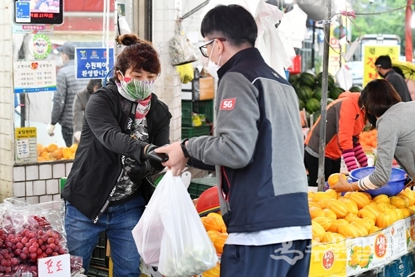 정자시장에서 과일과게를 운영하는 상인이 마스크를 끼고 일하고 있다.(사진=수원시)