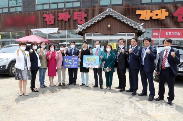 정장선 평택시장(오른쪽에서 6번째)이 코로나19 확진자가 다녀가 피해를 입은 세교동 소재 식당을 찾아가 시의원, 간부공무원들과 함께 '힘내세요 사장님' 캠페인을 전개하고 있다.(사진=평택시)