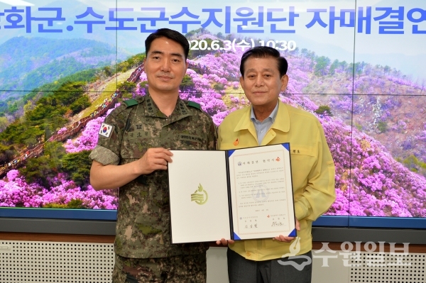 유천호 강화군수(오른쪽)과 김상철 육군 수도군수지원단장이 협약서를 들어보이고 있다.(사진=강화군)