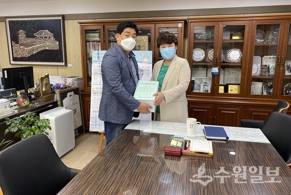 김영진 수원아이파크시티 마을교육공동체추진위원회 회장(왼쪽)이 조명자 수원시의회 의장에게 서명부를 전달하고 있다.(사진=수원아이파크시티 마을교육공동체추진위원회)
