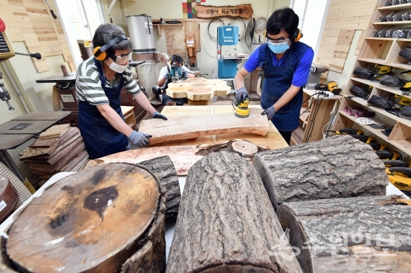 수원시 숲 자원화 사업단이 목공체험장에서 버려진 고사목을 활용한 시설물을 만들고 있다.(사진=수원시)