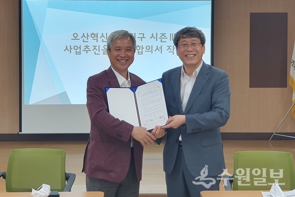 곽상욱 오산시장(왼쪽)과 남현석 화성오산교육지원청 교육장이 협약서를 함께 들어보이고 있다.(사진=오산시)