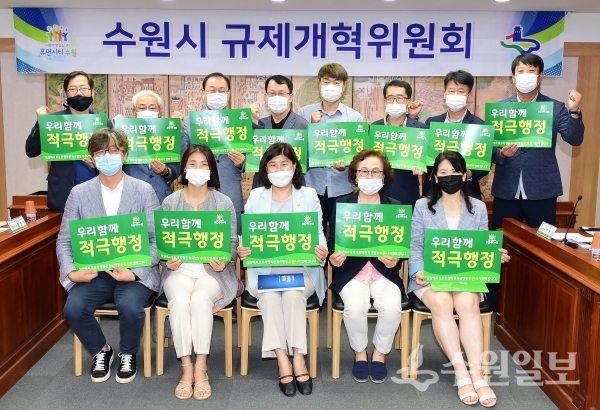 조청식 제1부시장(뒷줄 왼쪽 4번째)을 비롯한 수원시 규제개혁위원회 위원들이 ‘우리함께 적극행정’이라는 문구가 적힌 손팻말을 들고, 기념촬영을 하고 있다.(사진=수원시)