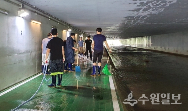 영통구 관계공무원들이 집중호우로 더럽혀진 하천통행로를 정비하고 있다.(사진=영통구)