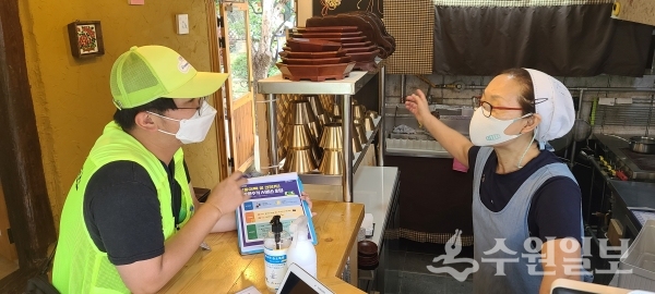 행궁동 마을관리소 지킴이가 행궁동 일대 카페를 방문해 특화사업에 대해 설명을 하고 있다.(사진=수원시)