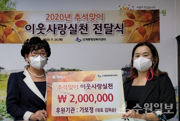김외순 가보정 대표(왼쪽)가 임정완 인계동장에게 200만원을 전달하고 있다.(사진=인계동)