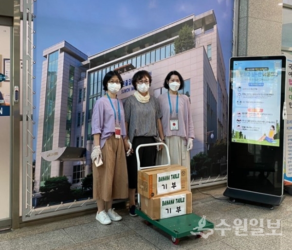 수원출입국 외국인청 봉사자들이 광교 맛집 '바나나테이블'로부터 영화 및 음악 CD를 기부받은 뒤 기념촬영을 하고 있다.