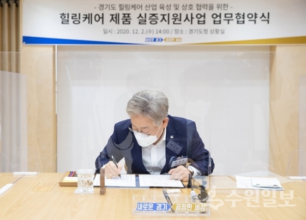 이재명 경기도지사가 힐링케어 신산업 육성 위한 협약서에 서명을 하고 있다.(사진=경기도)