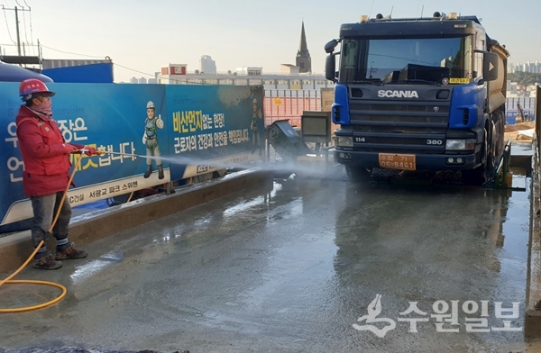 공사장 통행 트럭에 물을 뿌리고 있다.(사진=장안구)